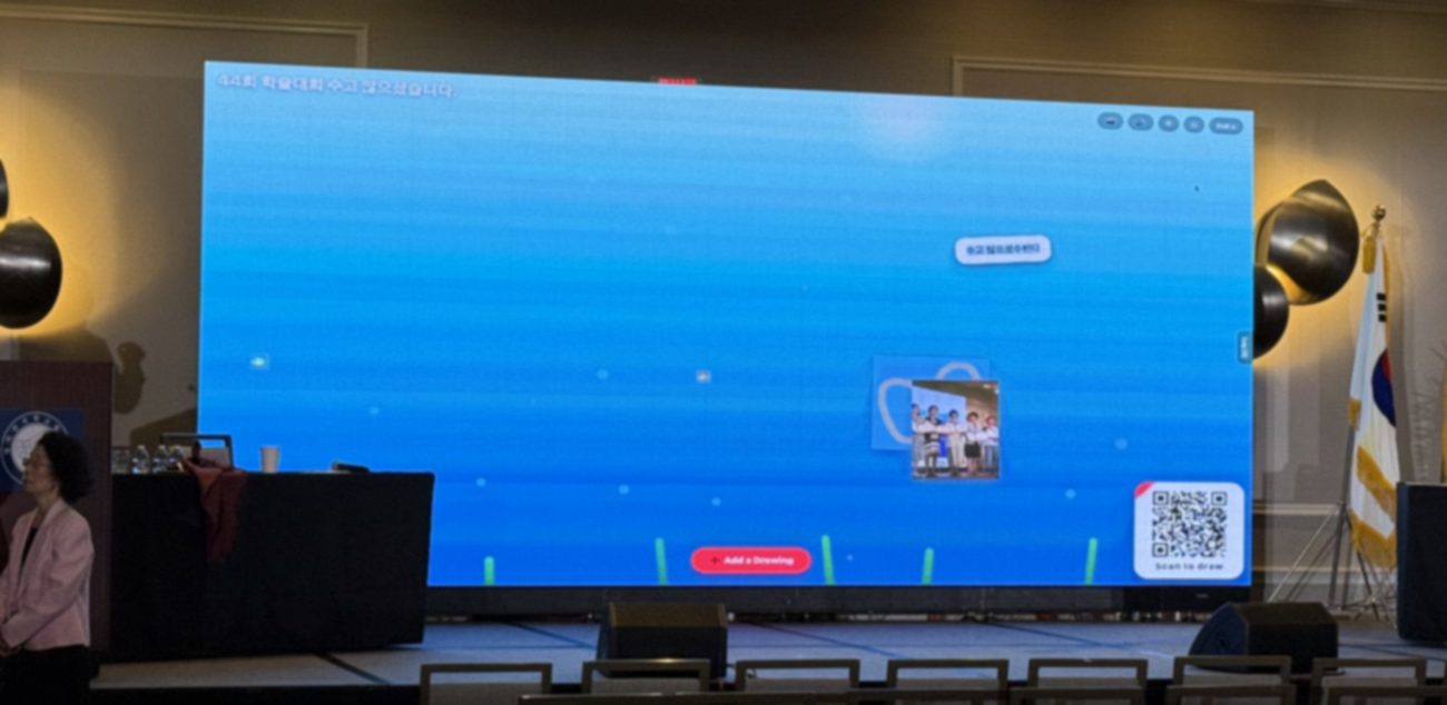 A conference big screen displaying messages of encouragement sent by attendees from their phones in real time